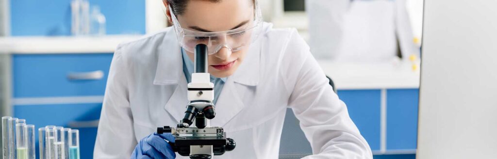 woman peering into microscope
